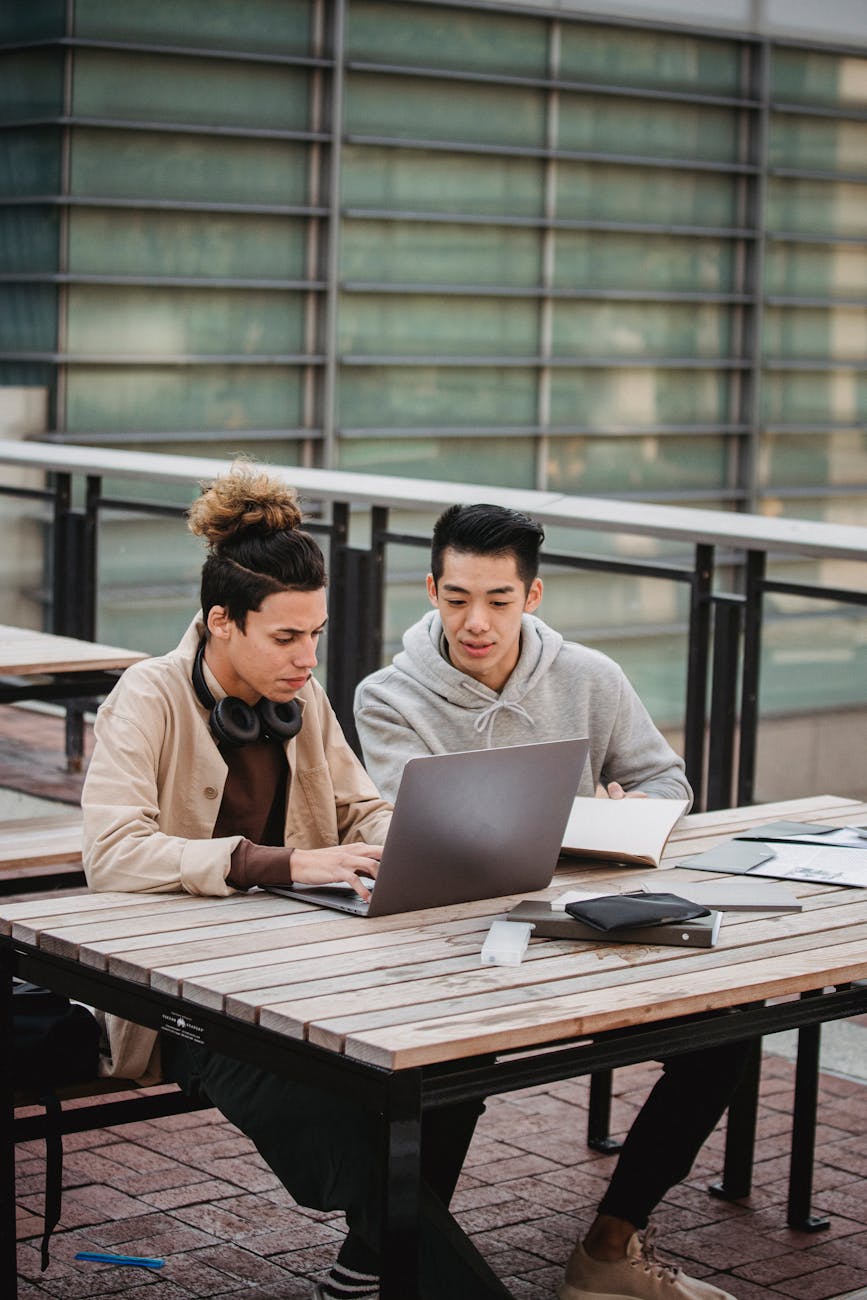 serious diverse students looking at laptop